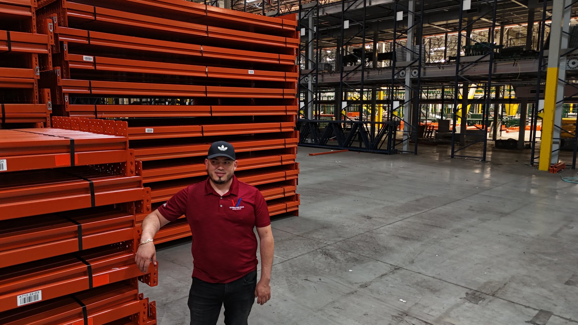 Luis of Warehouse Rack Installation beside staged rack components