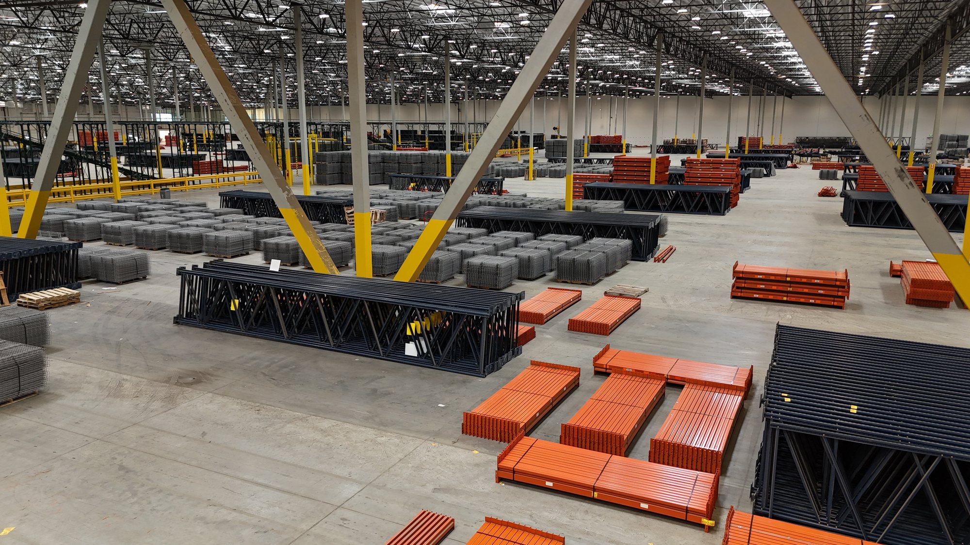 Large warehouse floor staged with rack frames, beams and decking