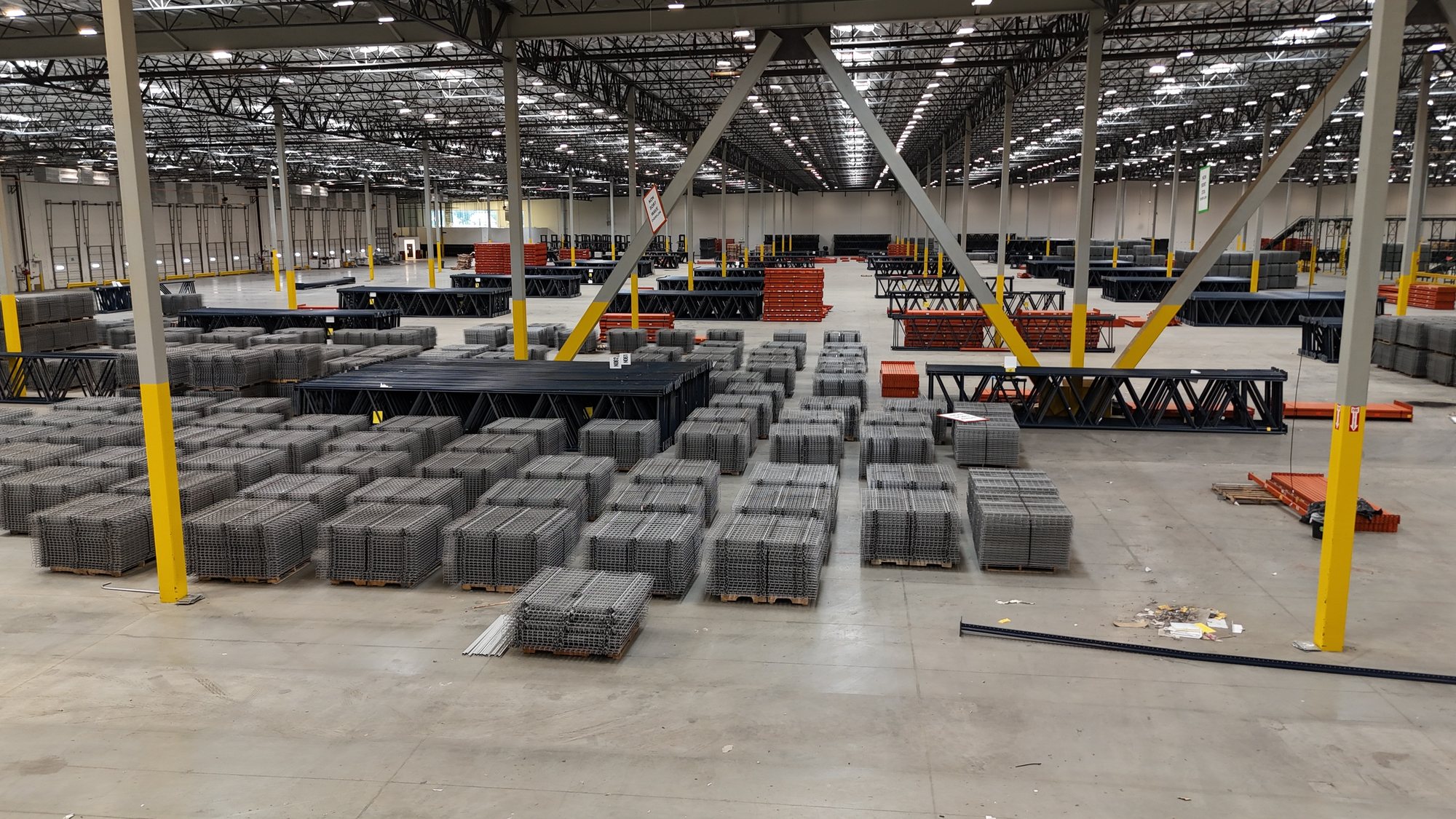 Warehouse floor organized with pallet rack components and wire decking